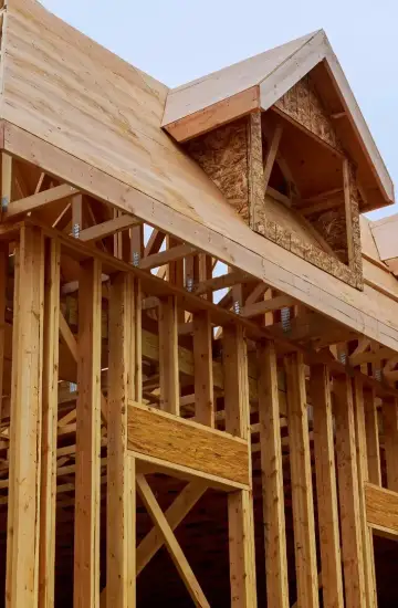 Wooden house frame under construction, symbolizing growth and strategic planning.