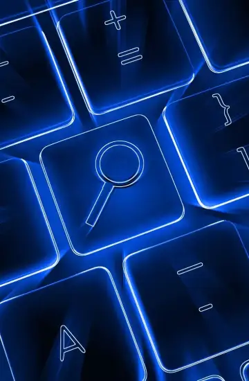 Glowing blue keyboard with a magnifying glass symbol on a key, representing ecommerce SEO and paid search strategy.