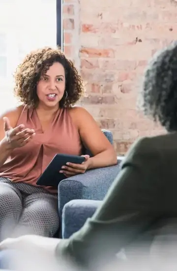 Therapist having a conversation with a client in a bright, modern office, symbolizing organic traffic growth.