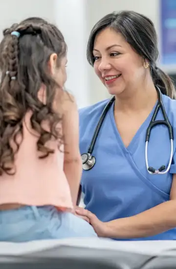 Smiling healthcare provider with a young patient in a clinical setting, representing increased brand trust in healthcare.