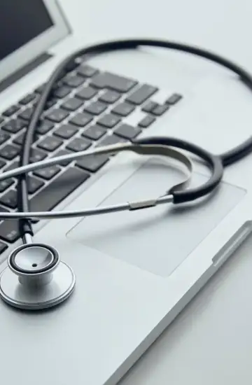 Stethoscope resting on a laptop keyboard, symbolizing the intersection of healthcare and digital marketing strategy.