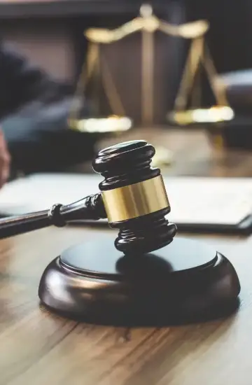 Close-up of a judge’s gavel on a desk with legal scales in the background, representing legal industry marketing success.