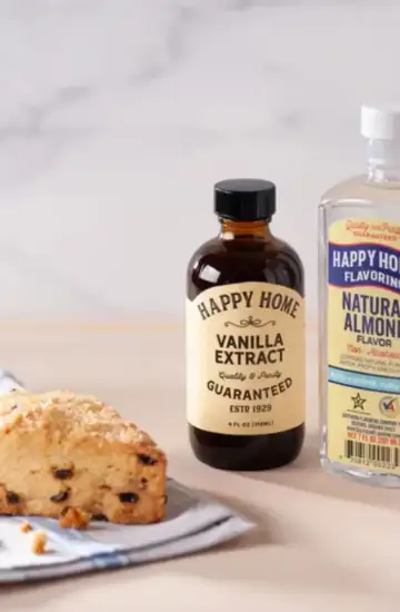 Close-up of vanilla and almond extract bottles next to a fresh scone, symbolizing local brand growth through SEO.