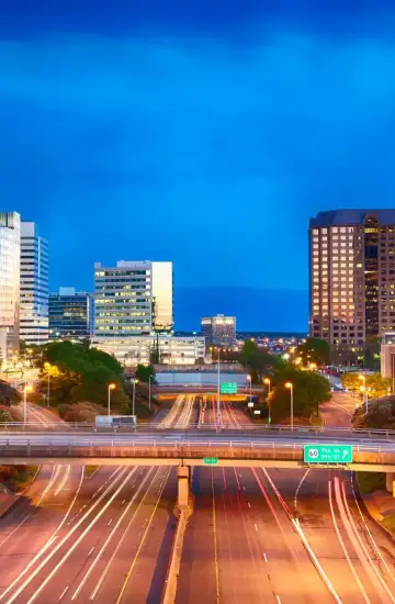 Downtown Richmond highway with light trails and office buildings at dusk, showing increased traffic and campaign momentum.