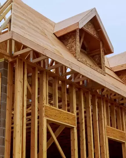 Wooden house frame under construction, symbolizing growth and strategic planning.