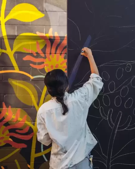 Artist sketching mural outlines, symbolizing creativity and tailored marketing work.