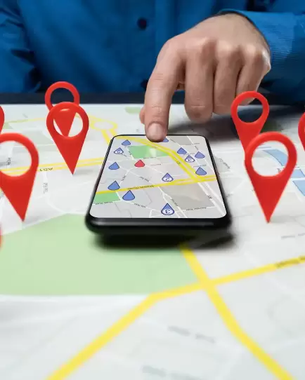 Person using smartphone on a map with location pins, symbolizing local SEO strategy.
