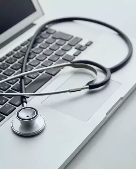 Stethoscope resting on a laptop keyboard, symbolizing the intersection of healthcare and digital marketing strategy.