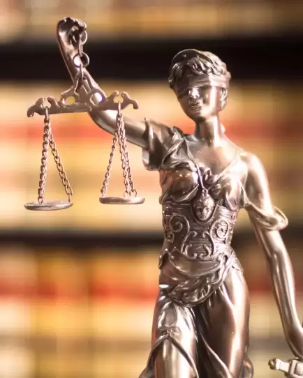 Statue of Lady Justice holding balanced scales in front of law books, symbolizing modern digital marketing for law firms.
