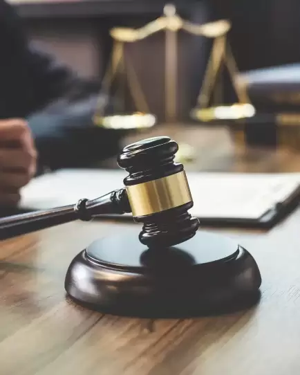 Close-up of a judge’s gavel on a desk with legal scales in the background, representing legal industry marketing success.