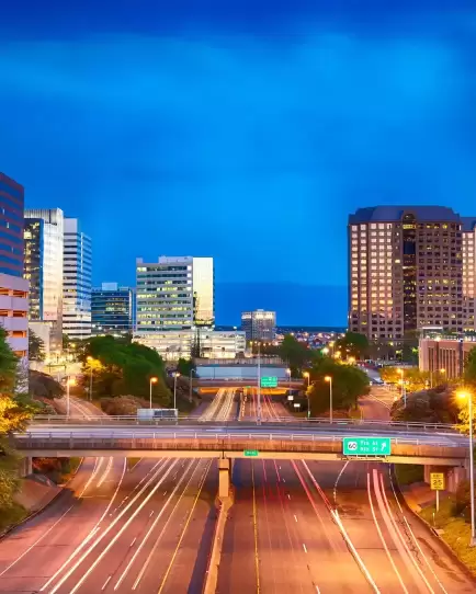 Downtown Richmond highway with light trails and office buildings at dusk, showing increased traffic and campaign momentum.