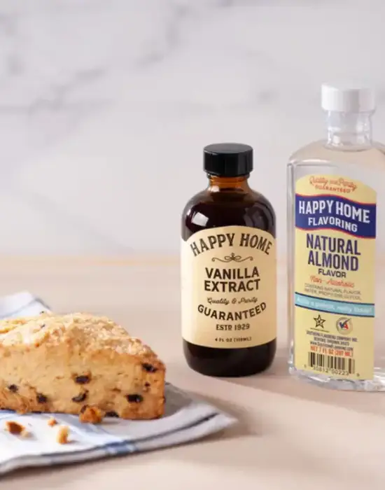 Close-up of vanilla and almond extract bottles next to a fresh scone, symbolizing local brand growth through SEO.