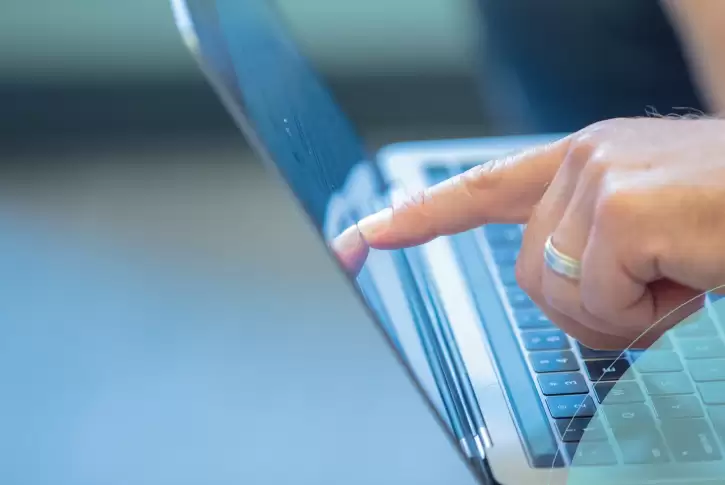 Close up of finger pointing to computer screen