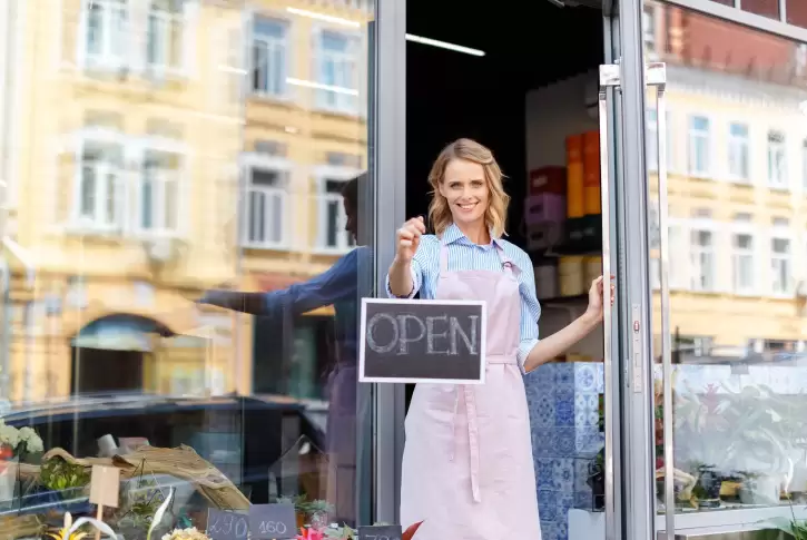 Small business owner setting out "open" sign
