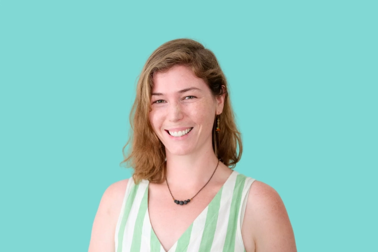 Portrait of Aimee Peake on a teal background.