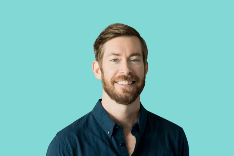 Portrait of Brian Forrester on a teal background.
