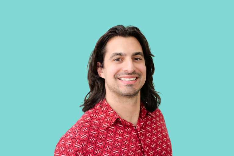 Portrait of Marco Primerano on a teal background.