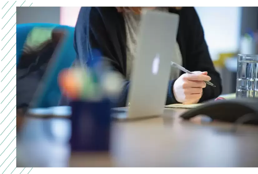 Team member writing on notepad