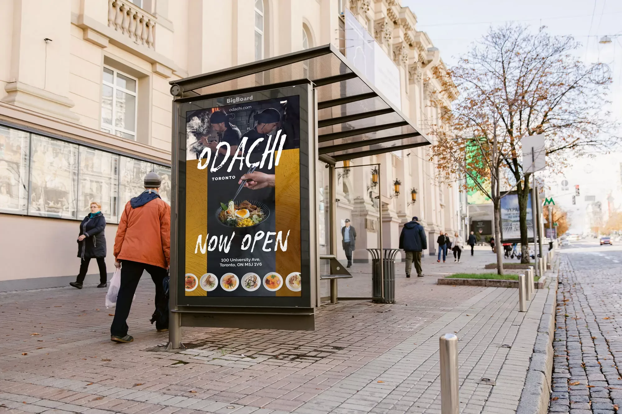 An ad displayed on the side of a bus stop shelter on a busy city sidewalk.